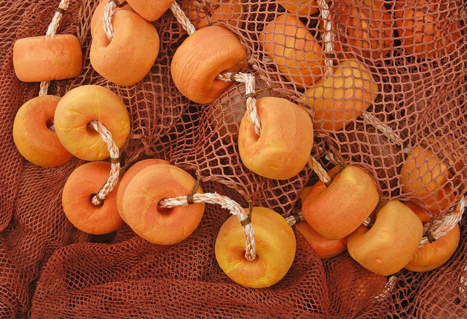 Oransje fiskegarn med fine og grove masker fotografert